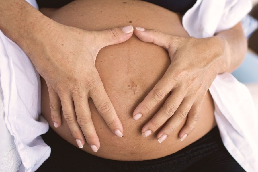 Hands cradling a pregnant belly